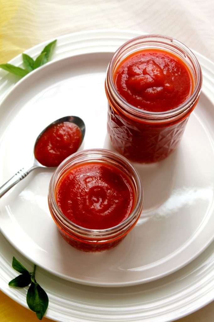 Homemade tomato ketchup made from fresh tomatoes in a glass bottle