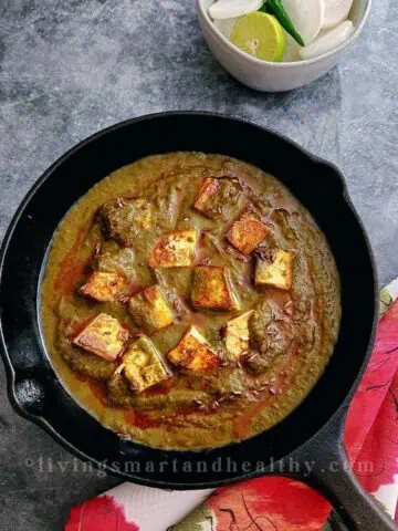 Palak paneer with soft paneer cubes in bright green spinach gravy served with roti