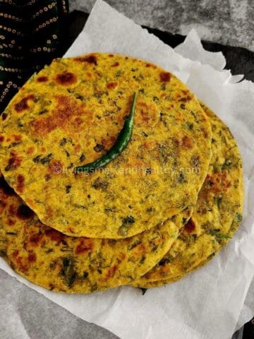 Close-up of soft bathua paratha highlighting green leafy texture