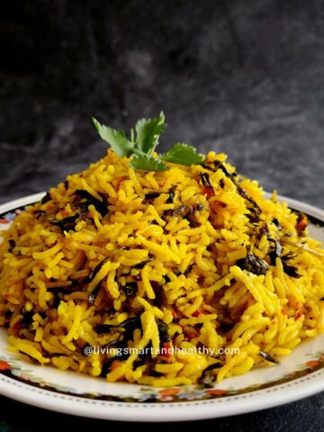 Close-up of steaming Sindhi Methi Pulao garnished with lemon juice and green chilies