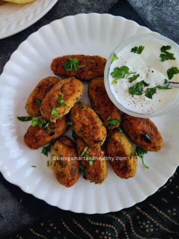 Golden tofu kebab on a plate with green chutney and lemon wedges